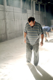 Készül a játéktér ahol 1500kiló lisztet teritenek el - előtérben Gazsó Gyögy - © theater.hu - Ilovszky  Béla